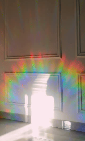 Rainbows thrown across a real room by a Glimmerprism suncatcher in direct sun
