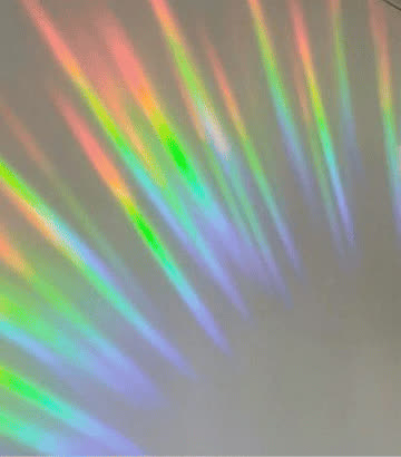 Rainbows thrown across a real room by a Glimmerprism suncatcher in direct sun