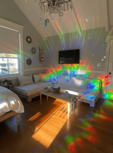 Rainbows thrown across a real room by a Glimmerprism suncatcher in direct sun