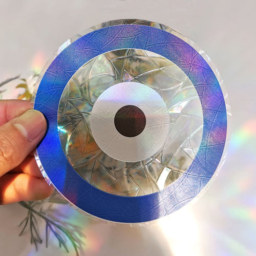 Evil Eye suncatcher sticker held to the light