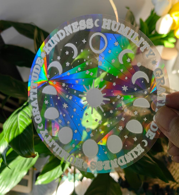 Moon Phases Mandala suncatcher sticker held to the light
