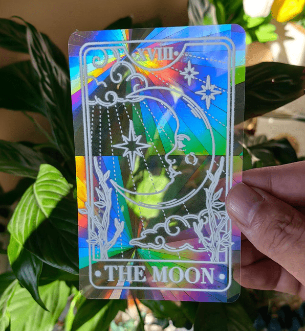 The Moon Tarot suncatcher sticker held to the light