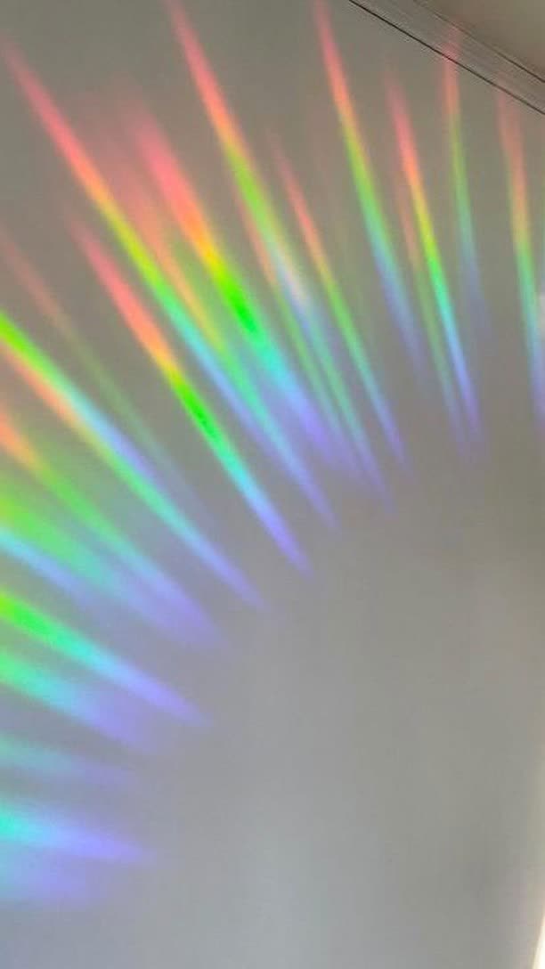 Rainbows thrown across a real room by a Glimmerprism suncatcher in direct sun